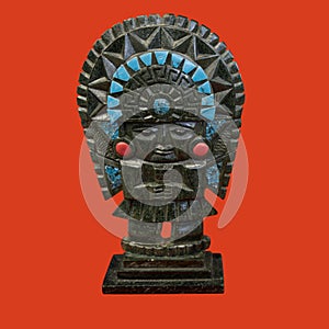 a decorative mayan statuette isolated on a red background