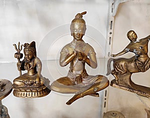 Decorative metal figurines of Buddha in a meditative pose on shop window