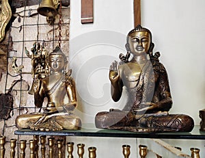 Decorative metal figurines of Buddha in a meditative pose on shop window