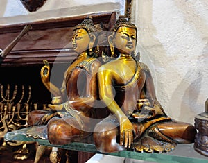 Decorative metal figurines of Buddha in a meditative pose on shop window