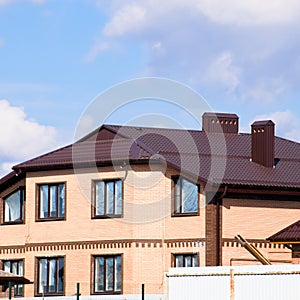 Decorative metal on the roof of a brick house. Fe