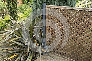Openwork wooden cladding on the edge of a garden terrace