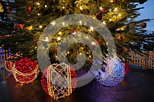 Decorative ornament and Christmas tree decorated with lights outdoors