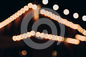 Decorative outdoor string lights at night time, Defocused Background, night city life backdrop, party time with Yellow