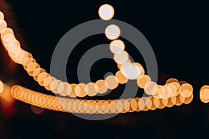 Decorative outdoor string lights at night time, Defocused Background, night city life backdrop, party time with Yellow