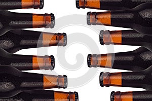 Decorative pattern of sealed brown beer bottles with porter and water drops isolated on white background