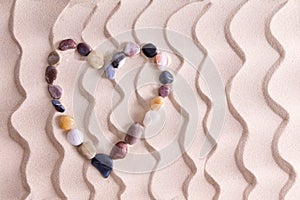 Decorative pebble heart on golden beach sand