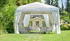Decorative place for ceremonies or entertainments. Outdoor reception under tents and trees.