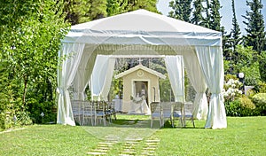 Decorative place for ceremonies or entertainments. Outdoor reception under tents and trees.