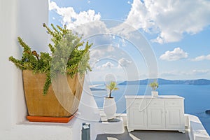 Decorative plants and elements of street design in mediteranian style, and Therasia on backdrop. Santorini island