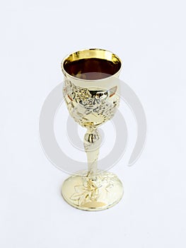Decorative plastic glass made in the form of a gilded cup for the utterance of Jewish prayers isolated on a white background photo