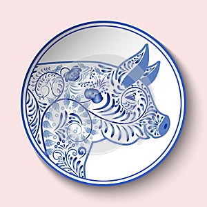 Decorative plate with blue patterned head of a pig. Symbol of new year 2019 isolated on pink background