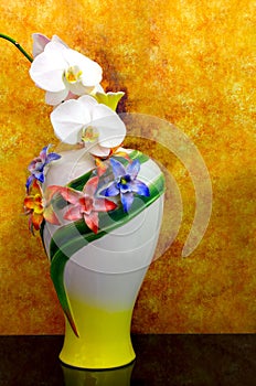 Decorative porcelain vase with white phalaenopsis orchids against grunge background