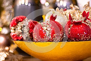 Decorative red pomegranate fruits in a bowl. Shallow depth of field