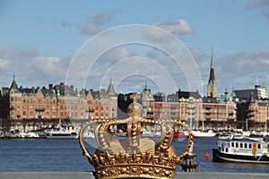 Decorative royal crown on the bridge with the city view of Stockholm, Sweden