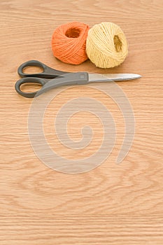 decorative rustic yellow orange yarn ball and scissors on a wood