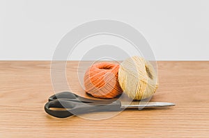 decorative rustic yellow orange yarn ball and scissors on a wood