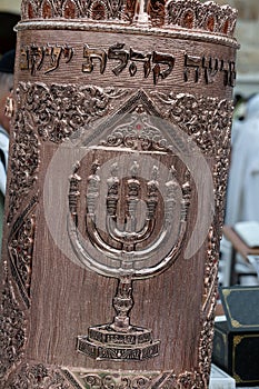 A decorative, Sephardic style Torah in a copper case designed with Jewish symbols, used during prayer services at the Western Wall