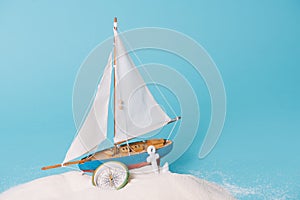 Decorative ship near anchor and compass in white sand o