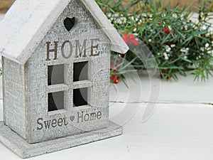 Decorative small house with sign Sweet home on white vintage background.