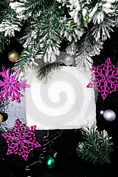 Decorative snowflake white and pink on black background. Christmas greeting card. Copy space. Top view.