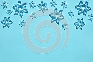 decorative snowflakes in bright sunlight on trendy light blue background