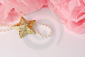 Decorative star, pearl beads and pink and white pom pom.