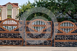 Brown decorative stone fence with baluster. against the house