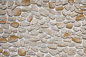 Decorative stone wall made of natural rocks of different colors and shapes plastered with white mortar as a background photo