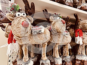 Decorative stuffed fluffy toys of reindeers on the shelf of christmas market fair