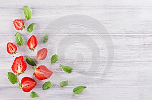 Decorative summer border of strawberry and mint leaf on white background with copy space, top view.