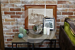 Decorative tables by the sofa. Pictures, candles, ball.