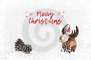 Decorative toy deer and pine cones on bokeh winter wooden background. Light soft Christmas background.
