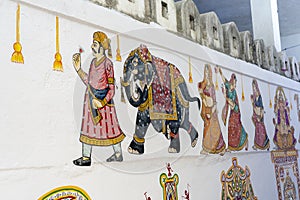 Decorative traditional drawings on the wall of the fence in the street of the city Udaipur, Rajasthan, India