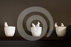 Decorative vases on a wooden shelf against the wall,