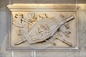 Decorative warrior sword, shield and ax artistic element on the facade of an old building in Vienna, Austria