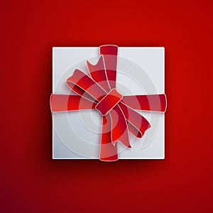 Decorative white gift box isolated on red background. Red bow, ribbon festive element for holiday design, christmas greeting card