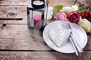 Decorative white heart, knife and fork on white plate on vintag