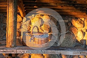 Decorative wicker basket on a wooden table against a stone wall background