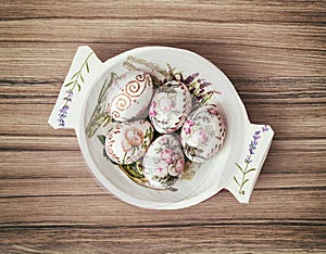 Decorative wooden bowl with painted Easter eggs, spring celebration