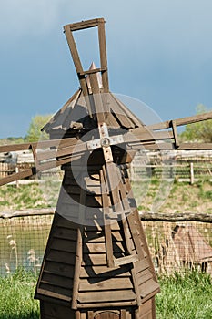 Decorative wooden mill standing outside in summer