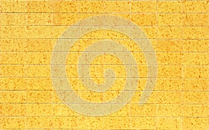 Decorative yellow tile socle on the facade of a house. Background and texture
