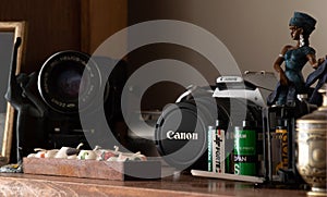 Decoratively placed old black-white 35mm films and old cameras on the shelf with african bibelot