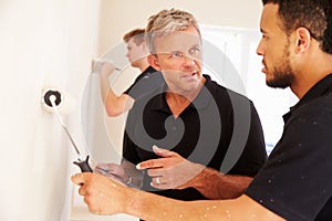 Decorator instructing colleague painting a room