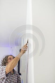 Decorator retouching imperfections in a wall photo