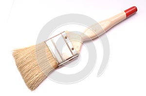 A decorator`s paint brush with beige colored handle