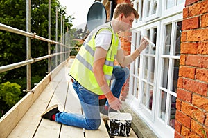 Decorator On Scaffolding Painting Exterior House Windows