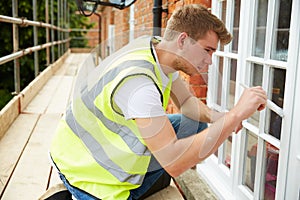 Decorator On Scaffolding Painting Exterior House Windows