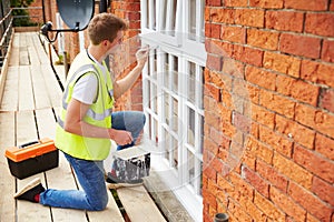 Decorator On Scaffolding Painting Exterior House Windows