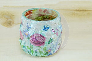 Decoupage decorated flower pattern jar on wooden background